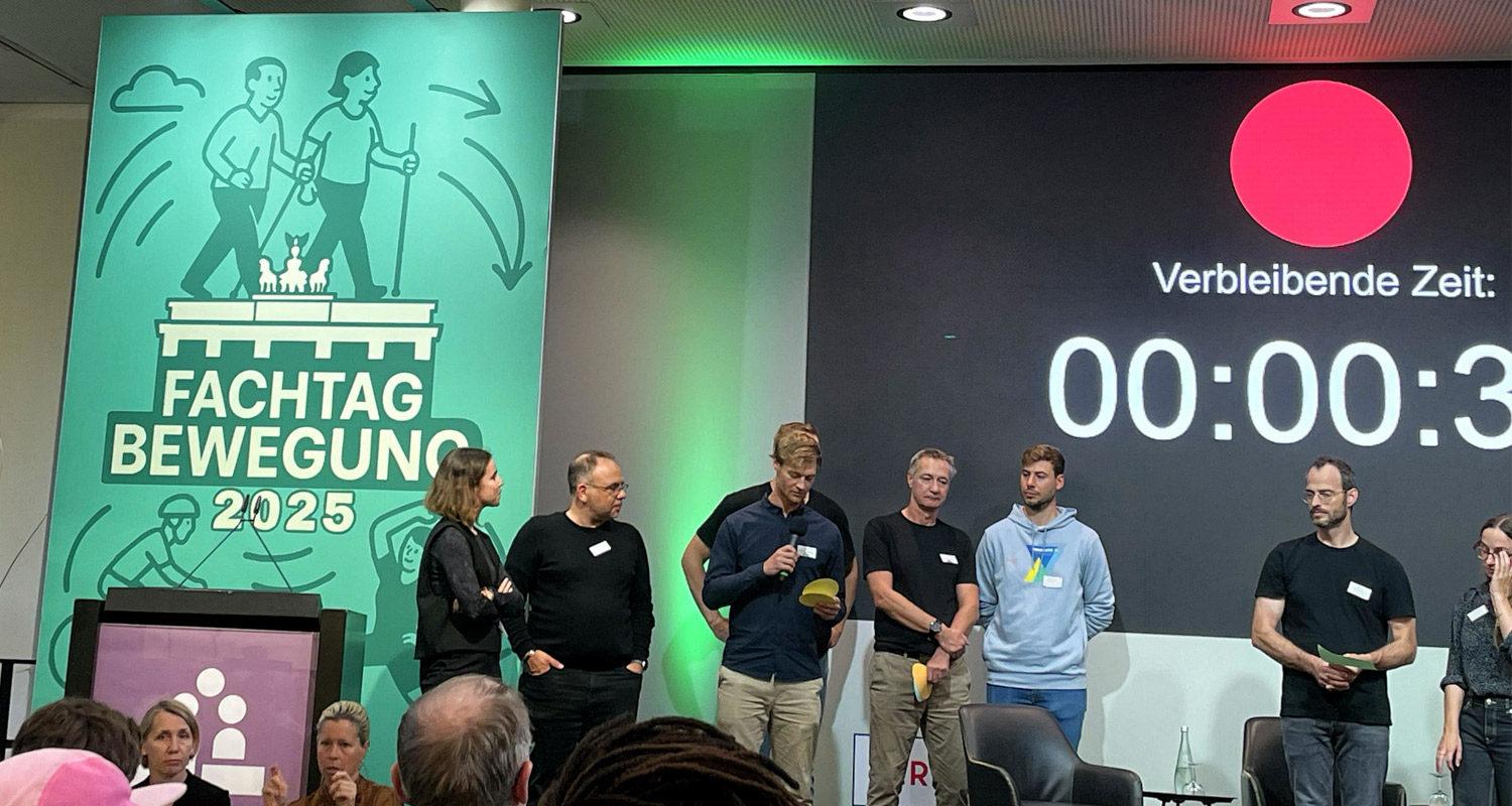 Julian Bollmann auf der Bühne ebim Fachtag Bewegung 2025 gemeinsam mit anderen Speakern und Speakerinnen